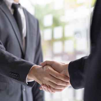 Twee handen die elkaar schudden.