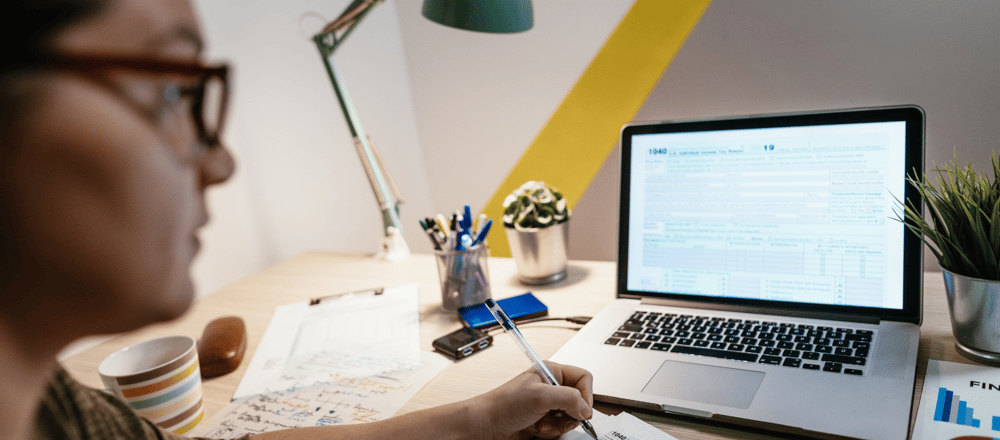 vrouw achter bureau met pen in hand