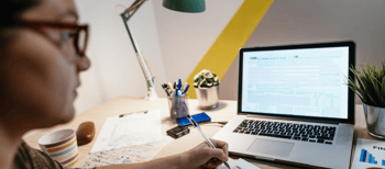 vrouw achter bureau met pen in hand