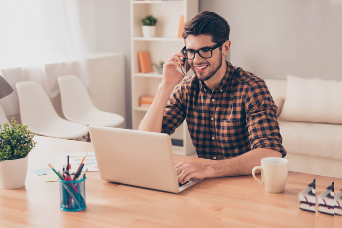 Sibbing | Man met bril en telefoon achter laptop