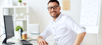 Glimlachende man met wit overhemd achter bureau
