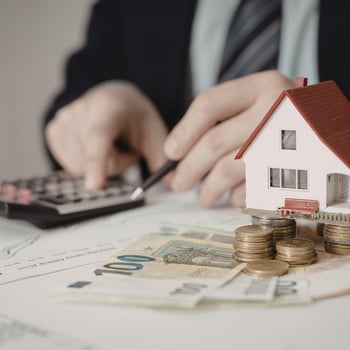 Iemand met een rekenmachine en geld naast zich